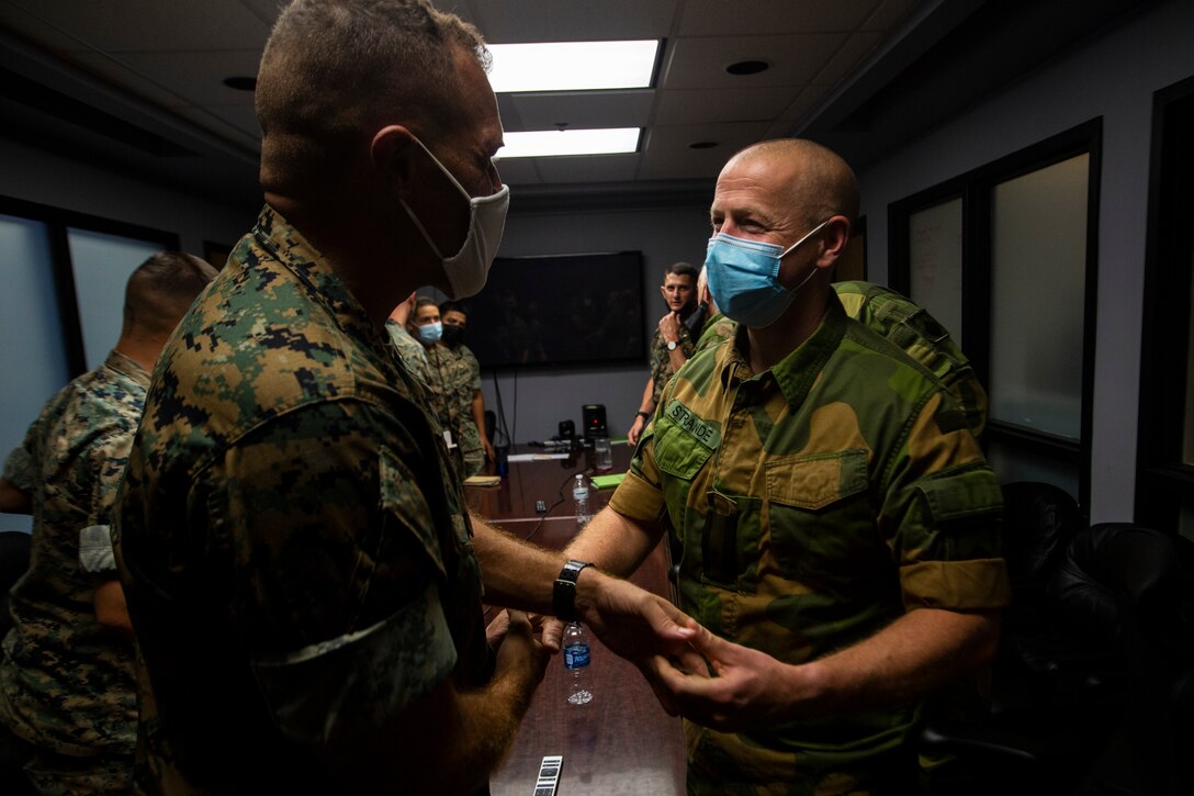 Norwegian Army Lt. Col. Per Espen Strande, commanding officer, Norwegian Military Intelligence Battalion, exchanges a challenge coin with U.S. Marine Corps Lt. Col. Eric Tee, commanding officer, 2nd Reconnaissance Battalion, during a visit aboard Marine Corps Base Camp Lejeune, N.C., Sept. 15, 2021. II Marine Expeditionary Force (MEF) intelligence commanders welcomed their counterparts with a tour of facilities and workspaces showcasing their capabilities. II MEF hosts also briefed on intelligence integration, mission accomplishment, and strengthening partnerships amongst the individual units. (U.S. Marine Corps photo by Sgt. Jesus Sepulveda Torres)