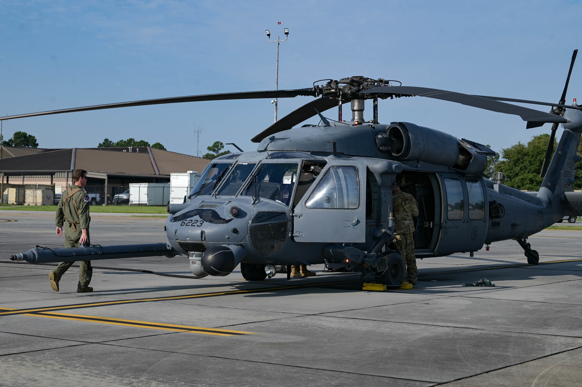 man walking around helicopter