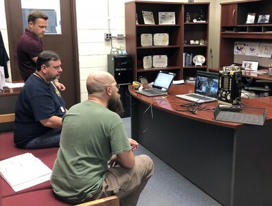 William Wall, left, shop supervisor at the U.S. Army Medical Materiel Agency's Medical Maintenance Operations Division at Tobyhanna, Pennsylvania, assists in providing telemaintenance support to members of the 51st Medical Logistics Company in July. Also pictured are biomedical equipment technicians Frank Cali, middle, and Vito Rizzo. (Photo Credit: Rachel Mummau)