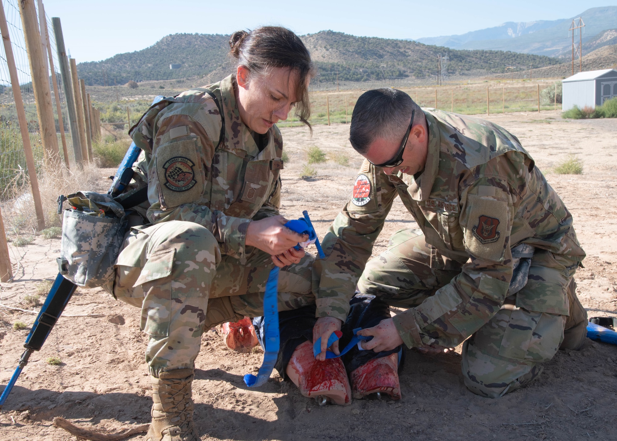 two airmen provide medical assistance to a dummy