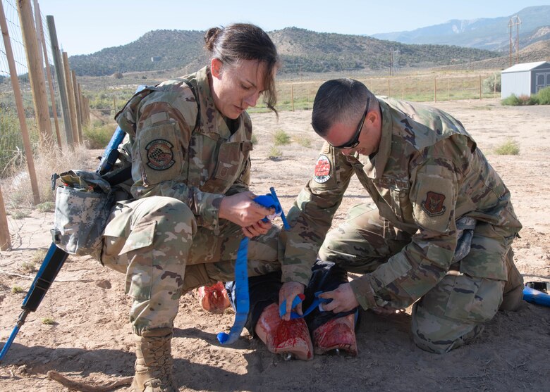 two airmen provide medical assistance to a dummy