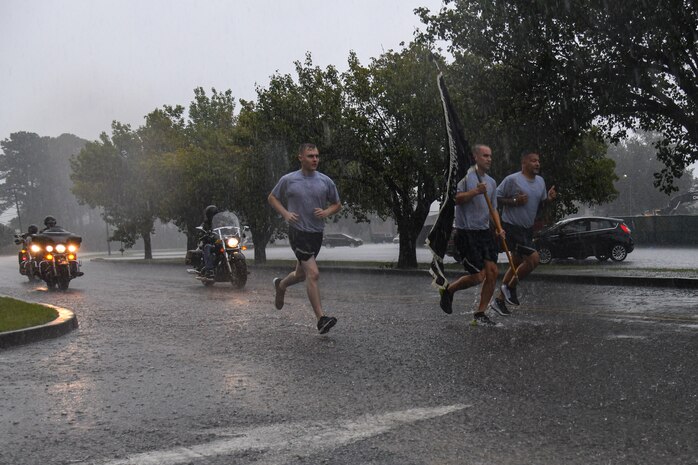 U.S. Air Force Col. Marc Greene, the 628th Air Base Wing and Joint Base Charleston commander, carries the POW/MIA flag while Combat Veterans Motorcycle Association rides along during the observed POW/MIA Recognition Day run at Joint Base Charleston, South Carolina, Sept. 16, 2021. Military personnel from different backgrounds came together all over base in honor of those prisoners of war and missing in action. Currently 83,000 service members unaccounted for. (U.S. Air Force photo by Airman 1st Class Jade Dubiel)