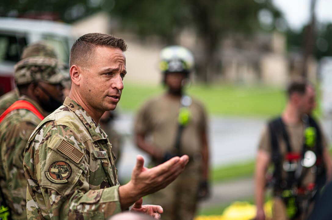 Photo of Airman talking to other Airmen