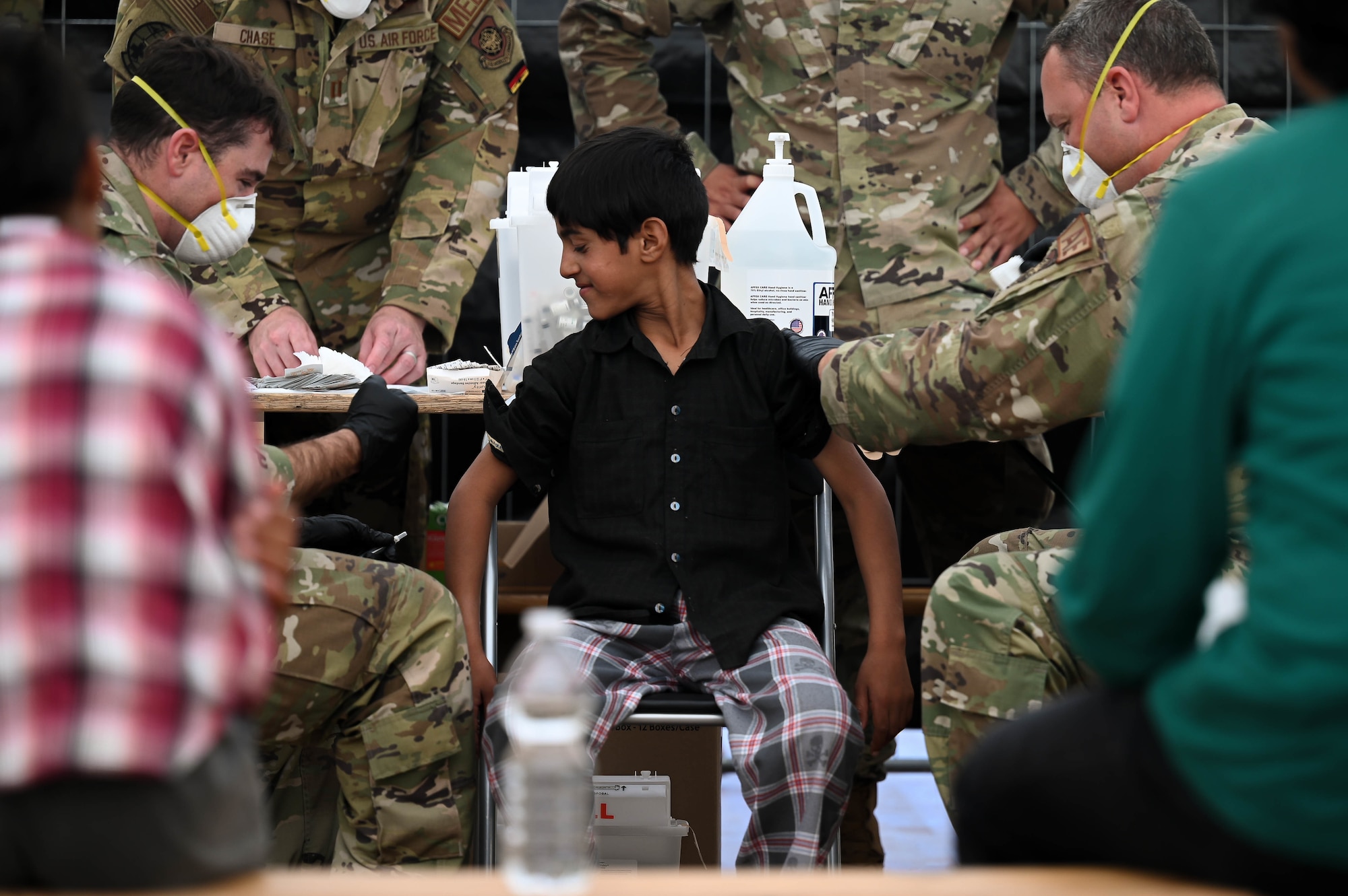 Airmen administer vaccines to evacuees.