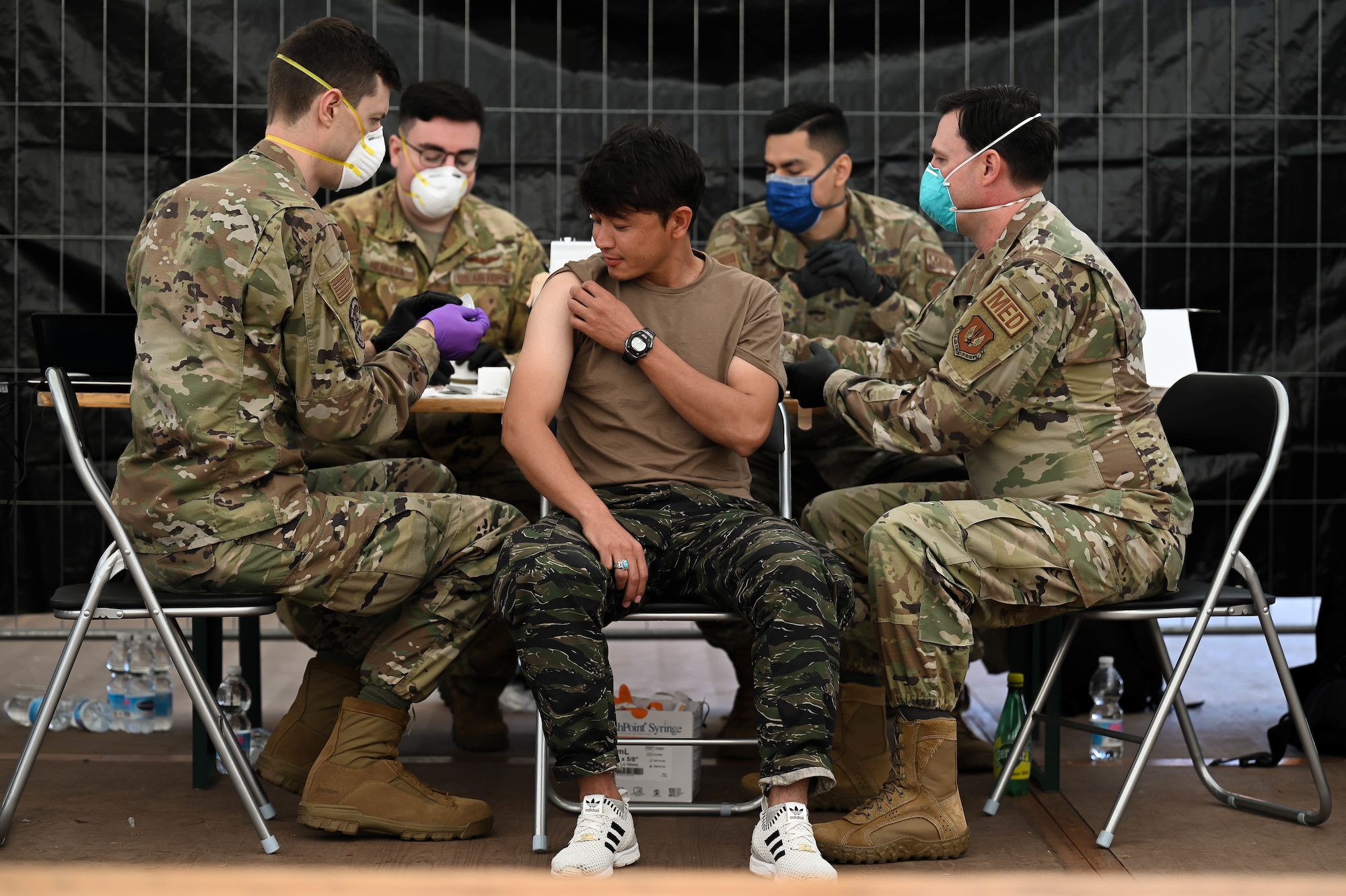 Airmen administer MMR vaccines to evacuee.