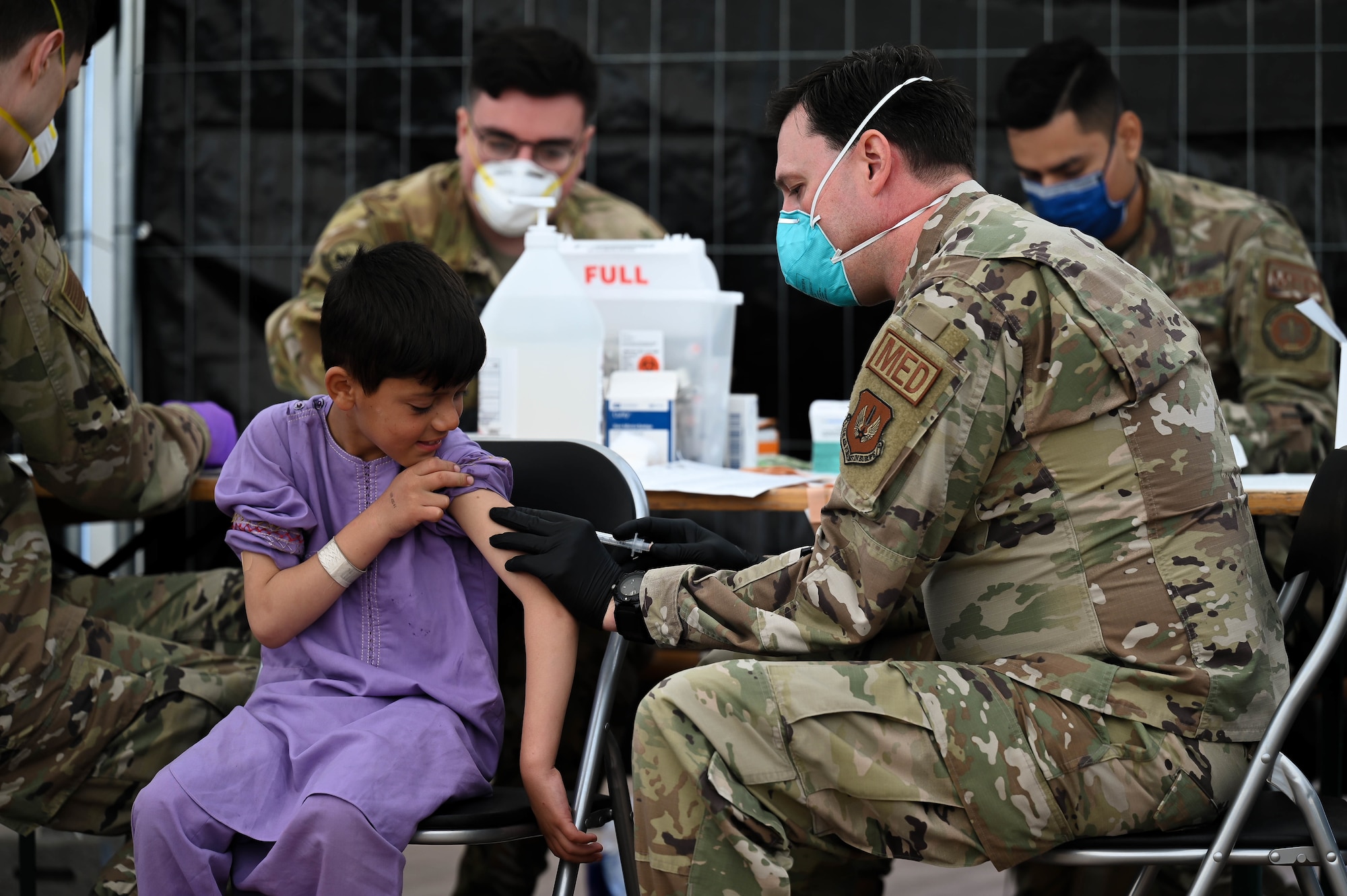 Airman administers MMR vaccine to evacuee.