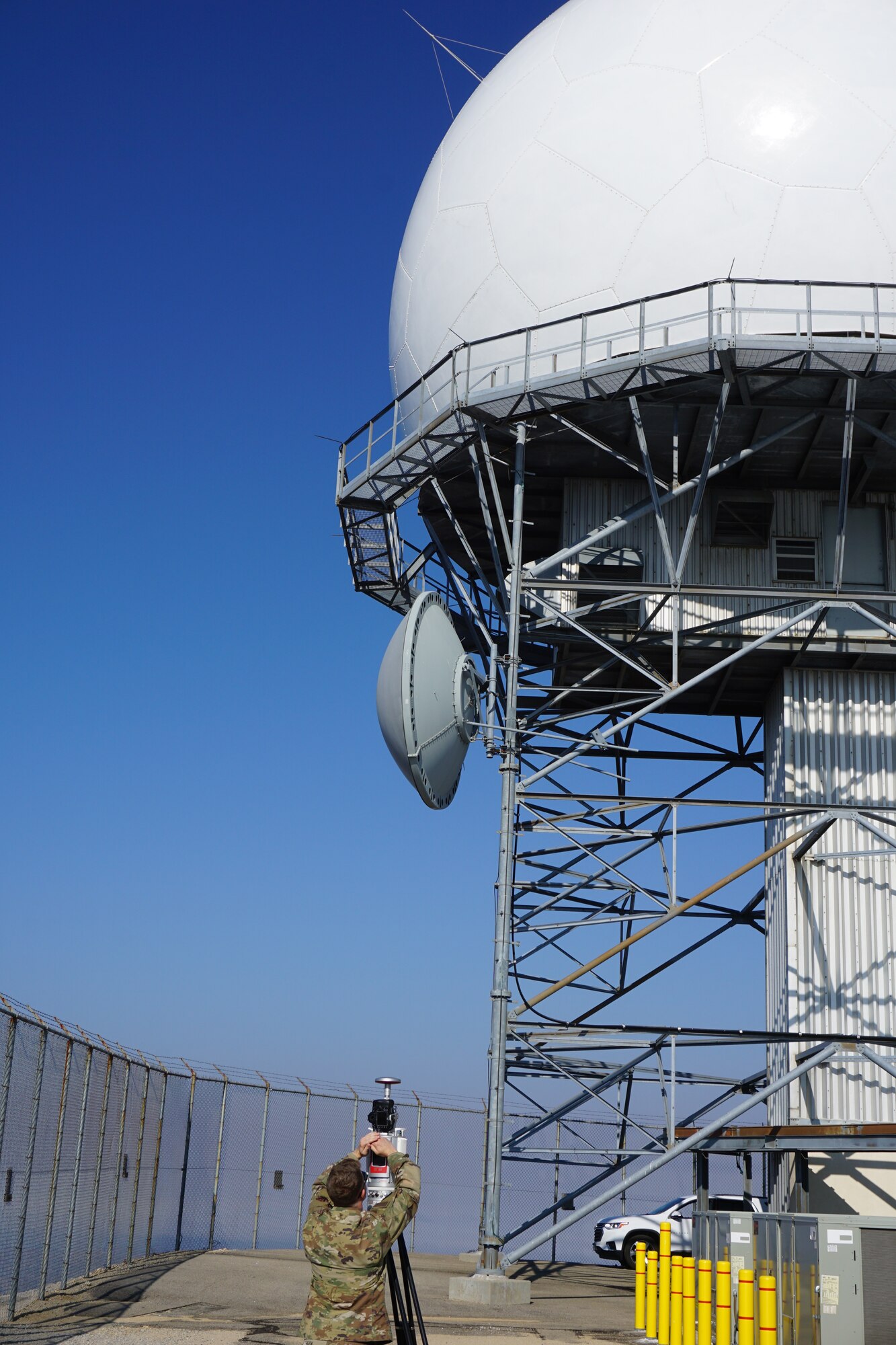 U.S. Airman standing in from of long range radar