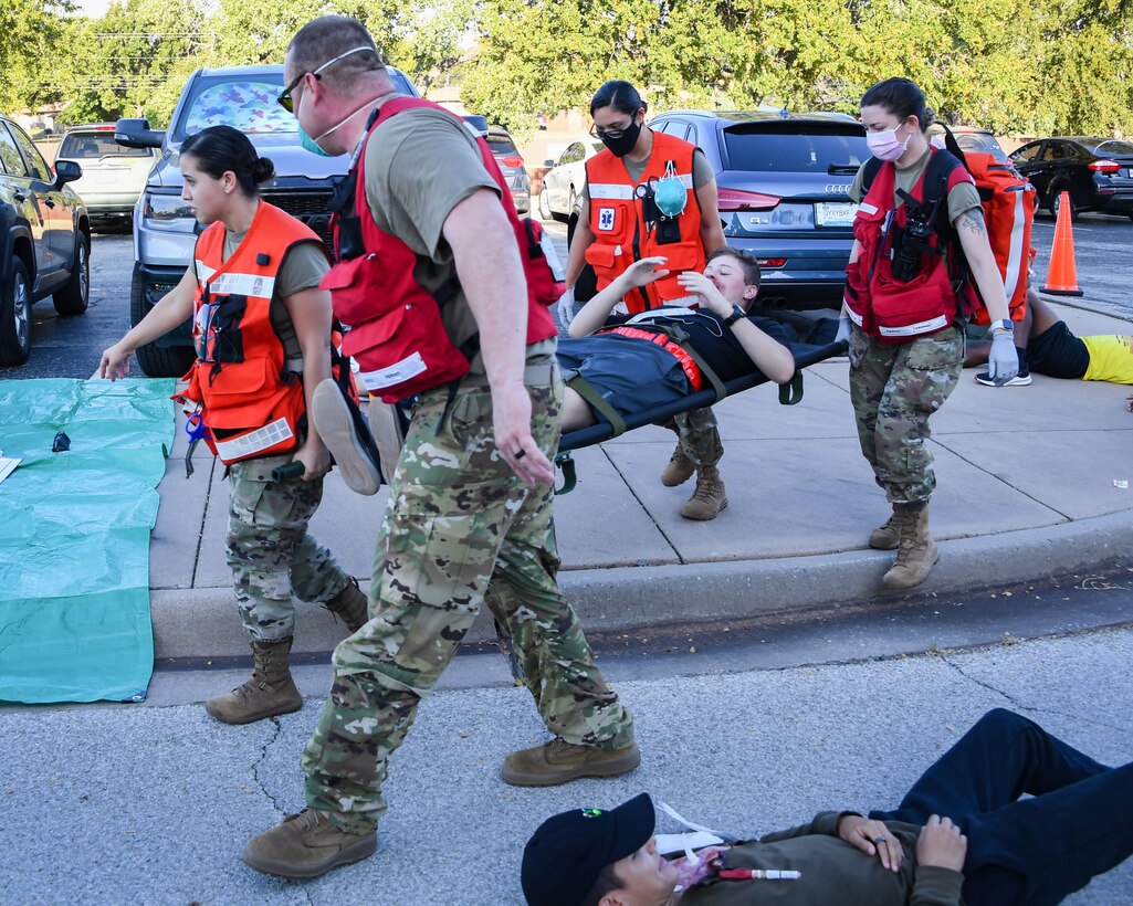 Personnel from the 82nd Medical Group carry a patient to an ambulance during a Ready Eagle exercise