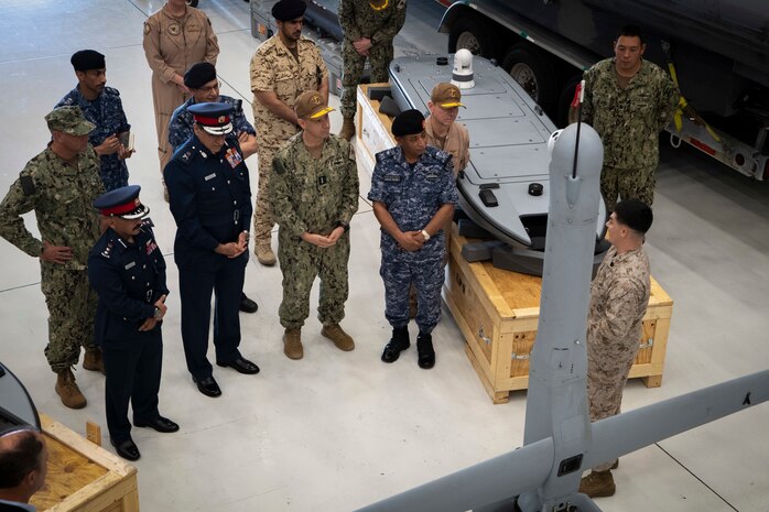 Vice Adm. Brad Cooper, commander of U.S. Naval Forces Central Command (NAVCENT), U.S. 5th Fleet, and Combined Maritime Forces, center right, along with Major Gen. Ala Abdulla Seyadi, commander of the Bahrain Coast Guard, center left; and Rear Adm. Mohammed Yousif Al Asam, commander of the Royal Bahrain Naval Force, right, listen to a presentation on an unmanned aerial vehicle V-BAT system. During the visit, Bahraini leaders committed to partnering with NAVCENT to accelerate integration of new unmanned systems into regional maritime operations.