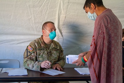 Indiana National Guard Sgt. 1st Class Joseph Stringer interprets for an Afghan guest during medical screening, Friday, Sept. 10, 2021, at Camp Atterbury in Indiana.