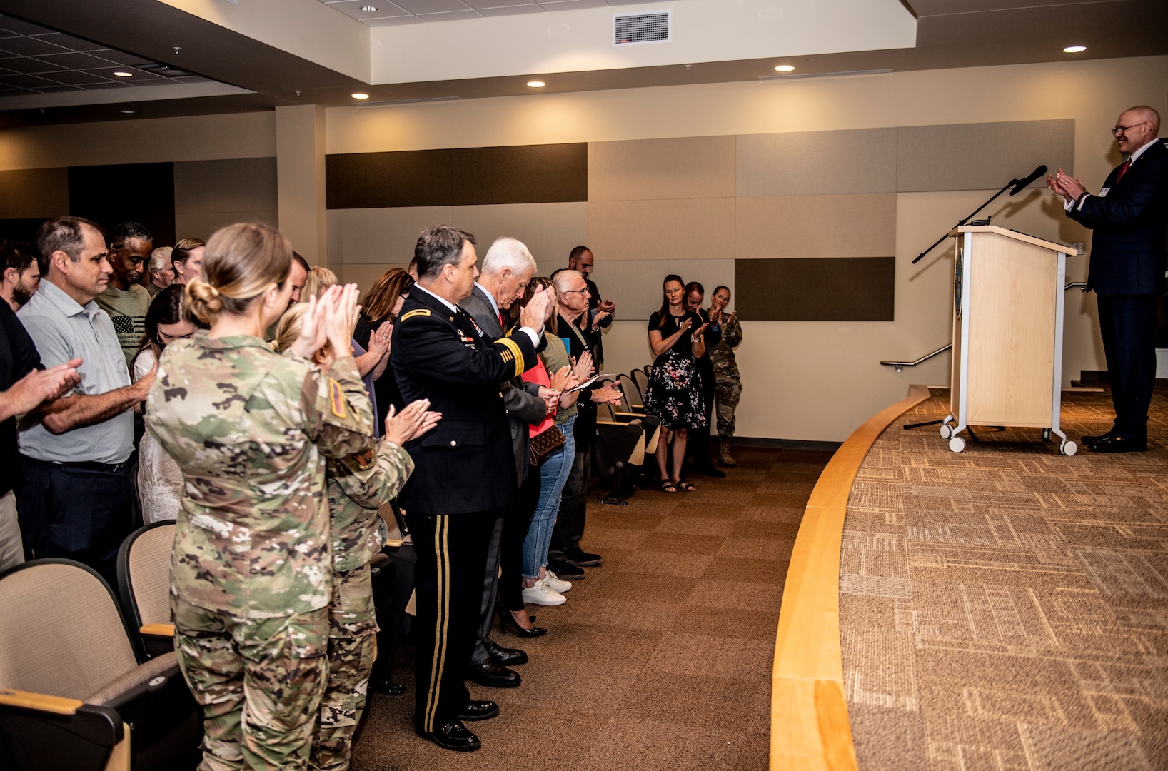 Oklahoma National Guardsmen, distinguished guest and Cameron Glass employees give Jim Cameron, Cameron Glass owner, a standing ovation at the Broken Arrow Armed Force Reserve Center, Sept. 21, 2021. Employer Support of the Guard and Reserve presents Cameron Glass with the Secretary of Defense Employer Support Freedom Award to recognize their unwavering support for Oklahoma National Guard and Reserve employees. (Oklahoma National Guard photo by Sgt. 1st. Class Mireille Merilice-Roberts)