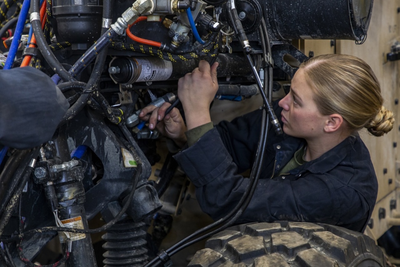 A service member works on a vehicle.