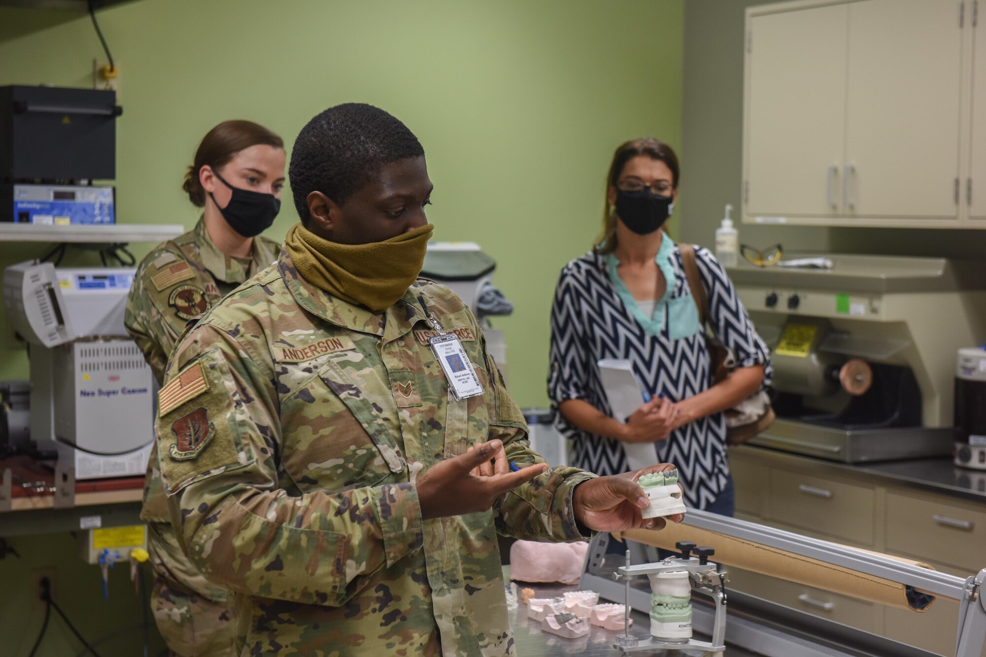 U.S. Air Force Staff Sgt. Richard Anderson, 97th Dental Flight dental laboratory technician, shows honorary commanders a ceramic mold of teeth he made at Altus Air Force Base, Oklahoma, Sept .17, 2021. The 97th Dental Flight provides various dental services ranging from preventive dentistry to comprehensive care including endodontics, prosthodontics, operative dentistry and oral surgery. (U.S. Air Force photo by 2nd Lt Cameron Silver)