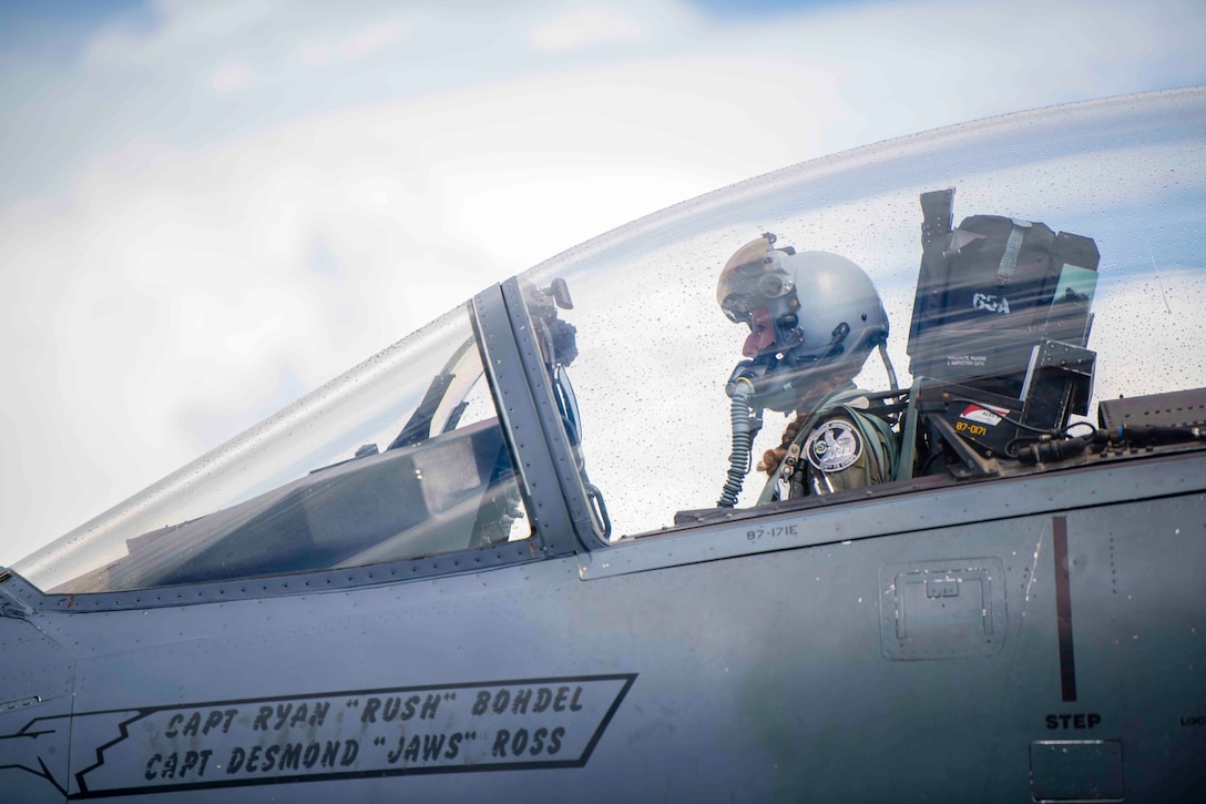 An airman sits in the cockpit of an aircraft.