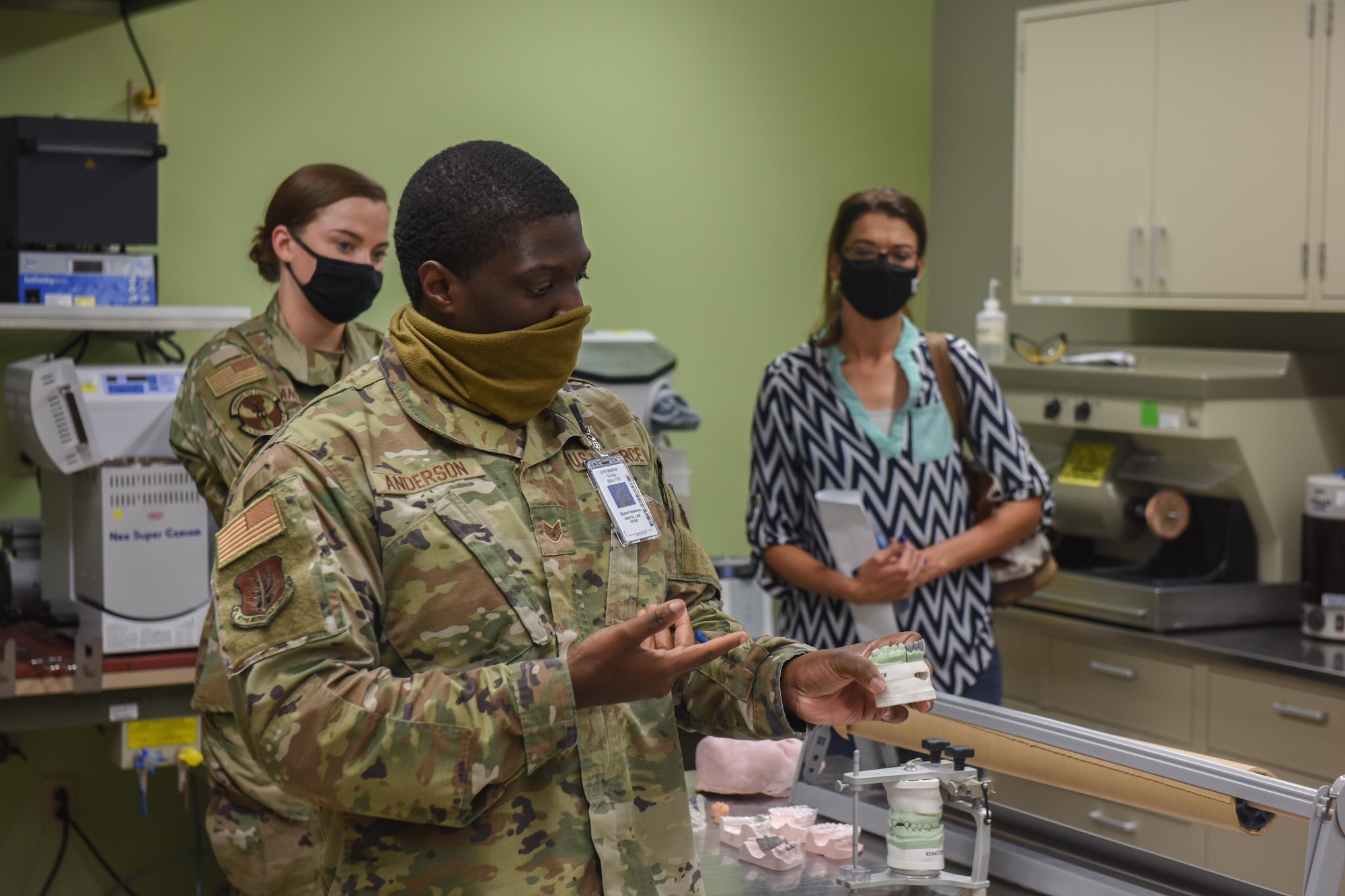 U.S. Air Force Staff Sgt. Richard Anderson, 97th Dental Flight dental laboratory technician, shows honorary commanders a ceramic mold of teeth he made at Altus Air Force Base, Oklahoma, Sept .17, 2021. The 97th Dental Flight provides various dental services ranging from preventive dentistry to comprehensive care including endodontics, prosthodontics, operative dentistry and oral surgery. (U.S. Air Force photo by 2nd Lt Cameron Silver)