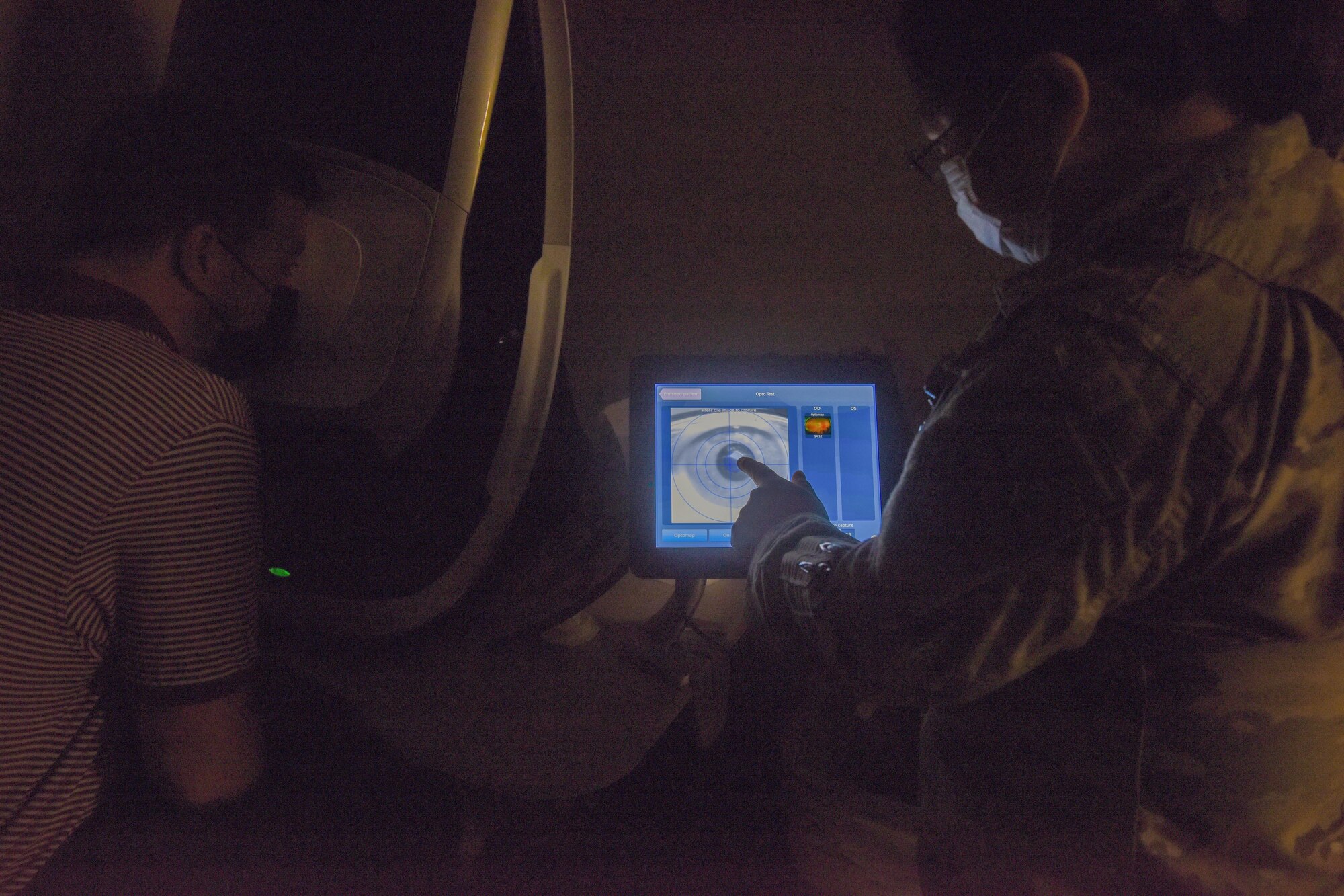 U.S. Air Force Staff Sgt. Lin Evenson, 97th Optometry Flight optometry specialist, shows Preston Gunkel, 97th Air Mobility Wing Judge Advocate honorary commander, a scan of his eye at Altus Air Force Base, Oklahoma, Sept .17, 2021. The 97th Optometry Flight’s services include glasses and contact lens prescriptions along with the treatment and management of ocular diseases that do not need surgical intervention. (U.S. Air Force photo by 2nd Lt Cameron Silver)