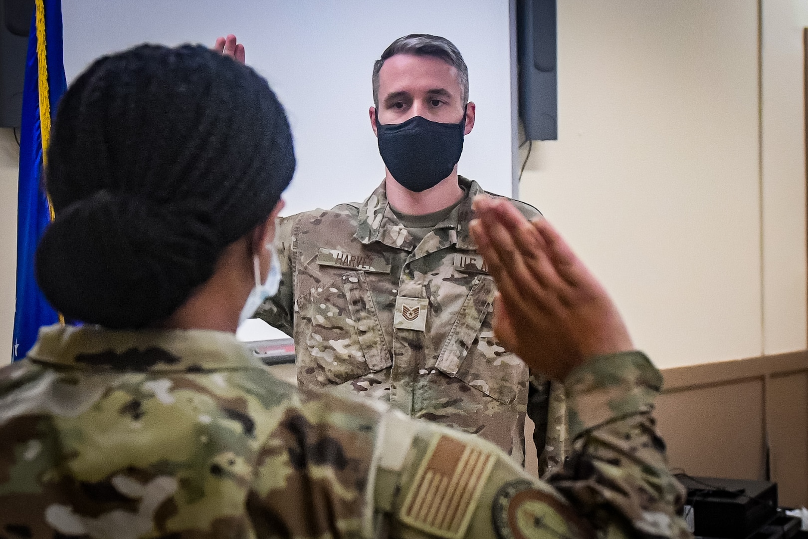 Service member taking the Oath of Enlistment being given to them by military officer.