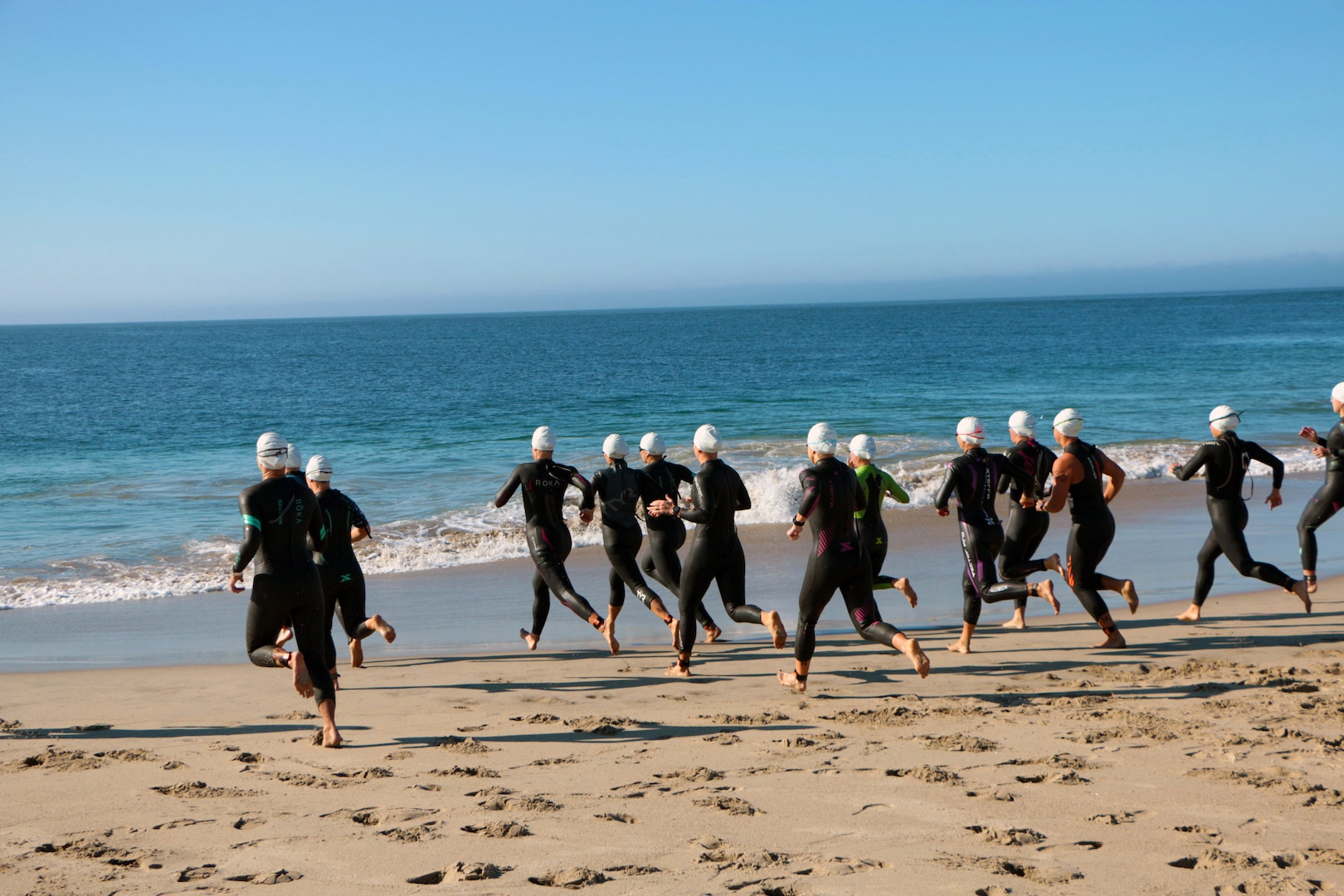 Athletes enter the Pacific Ocean at Point Mugu Beach for the start of the 2021 Armed Forces Triathlon Championship held on 11 September.  Service members from the Marine Corps, Navy (with Coast Guard) personnel), and Air Force (with Space Force personnel) compete for gold.  (Department of Defense Photo, Released)