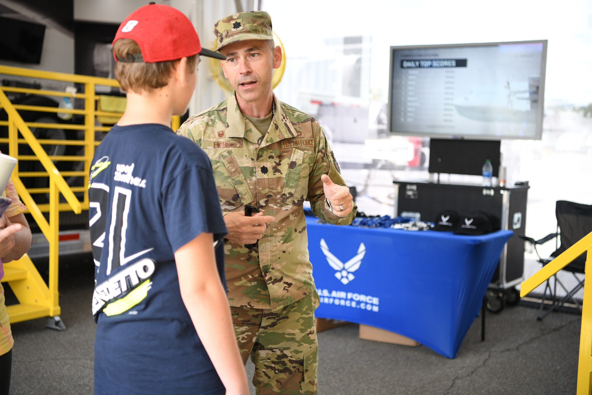 Lt. Col. Bryan Ewing, the 332nd Recruiting Squadron commander talks to a visitor inside the Air Force exhibit called "The Hangar" Sept. 18, 2021 at Bristol Motor Speedway, Bristol, Tennessee.