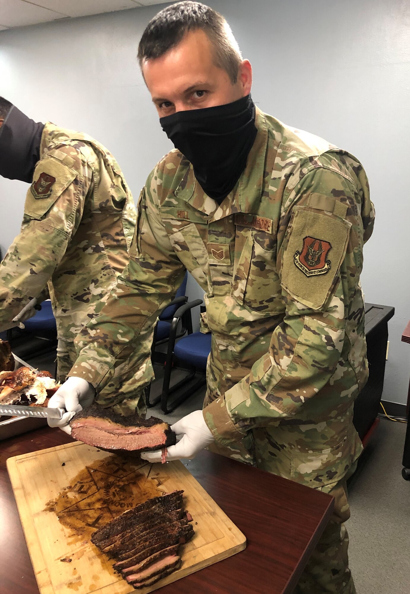 Tech. Sgt. Sean Hill, 73rd Aerial Port Squadron Special Handling Supervisor, serves brisket during the 73d APS 2020 Christmas Lunch event at Naval Air Station Joint Reserve Base Fort Worth, Texas. The pandemic caused Hill to expand his business by vacuum sealing his smoked meats so customers could eat BBQ whenever they wanted, without having to go out as often. Vacuum sealed BBQ will taste like it just came off the smoker up to six months after it is frozen said Hill. (courtesy photo)