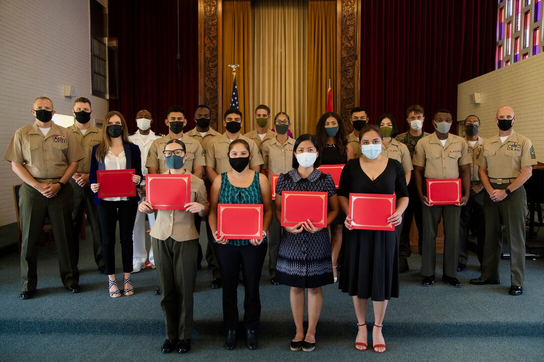 Newly naturalized U.S. citizens pose for a group photo with service members from Headquarters and Support Battalion, Marine Corps Installations Pacific – Marine Corps Base Camp Butler, after a naturalization ceremony at the Camp Foster Chapel, Camp Foster, Okinawa, Japan, Sept. 16, 2021. A total of 15 Marines and civilians from 13 countries swore the oath of allegiance and received their naturalization certificates to become U.S. citizens. (U.S. Marine Corps photo by Cpl. Ryan H. Pulliam)