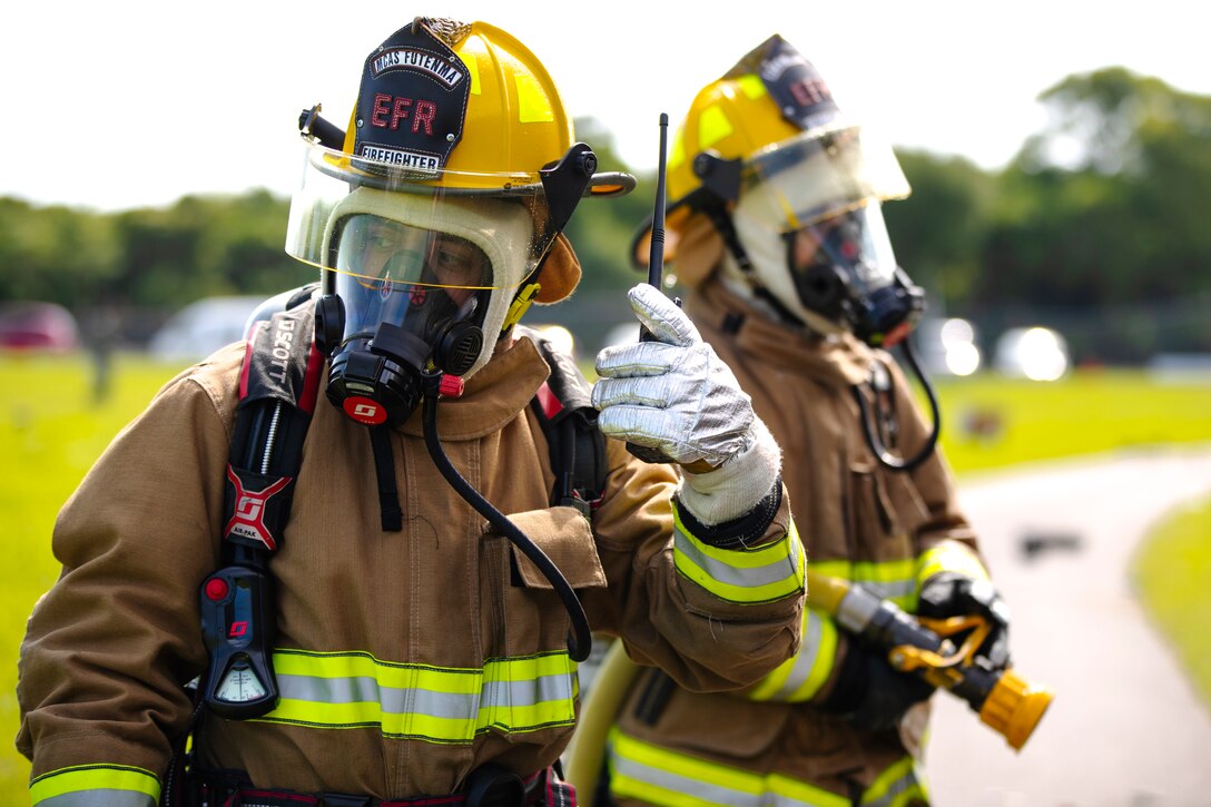 U.S. Marine Corps Sgt. Patricio Ortiz, left, and Cpl. Cass Cisneros, expeditionary firefighting and rescue specialists with the Marine Corps Air Station (MCAS) Futenma Expeditionary Crash, Fire and Rescue, Headquarters and Headquarters, Squadron MCAS Futenma, Marine Corps Installations Pacific, await for further instructions during an aircraft mishap drill near Gate 3 of Marine Corps Air Station (MCAS) Futenma, Okinawa, Japan, Sept. 21, 2021. The scenario was the signature event of Constant Vigilance 2021 on the air station and served to ensure MCAS Futenma and its personnel are able to respond to crises at a moment's notice. (U.S. Marine Corps photo by Cpl. Ryan H. Pulliam)