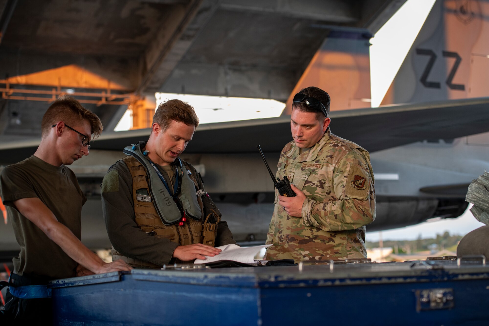 A pilot assigned to the 44th Fighter Squadron and two maintainers from the 18th Aircraft Maintenance Squadron review an F-15C Eagle maintenance log during pre-flight checks prior to a night flying training mission at Kadena Air Base, Japan, Sept. 22, 2021. Kadena Airmen regularly train to maintain their capability to provide unrivaled air power in support of U.S. Indo-Pacific Command objectives. (U.S. Air Force photo by Maj. Raymond Geoffroy)