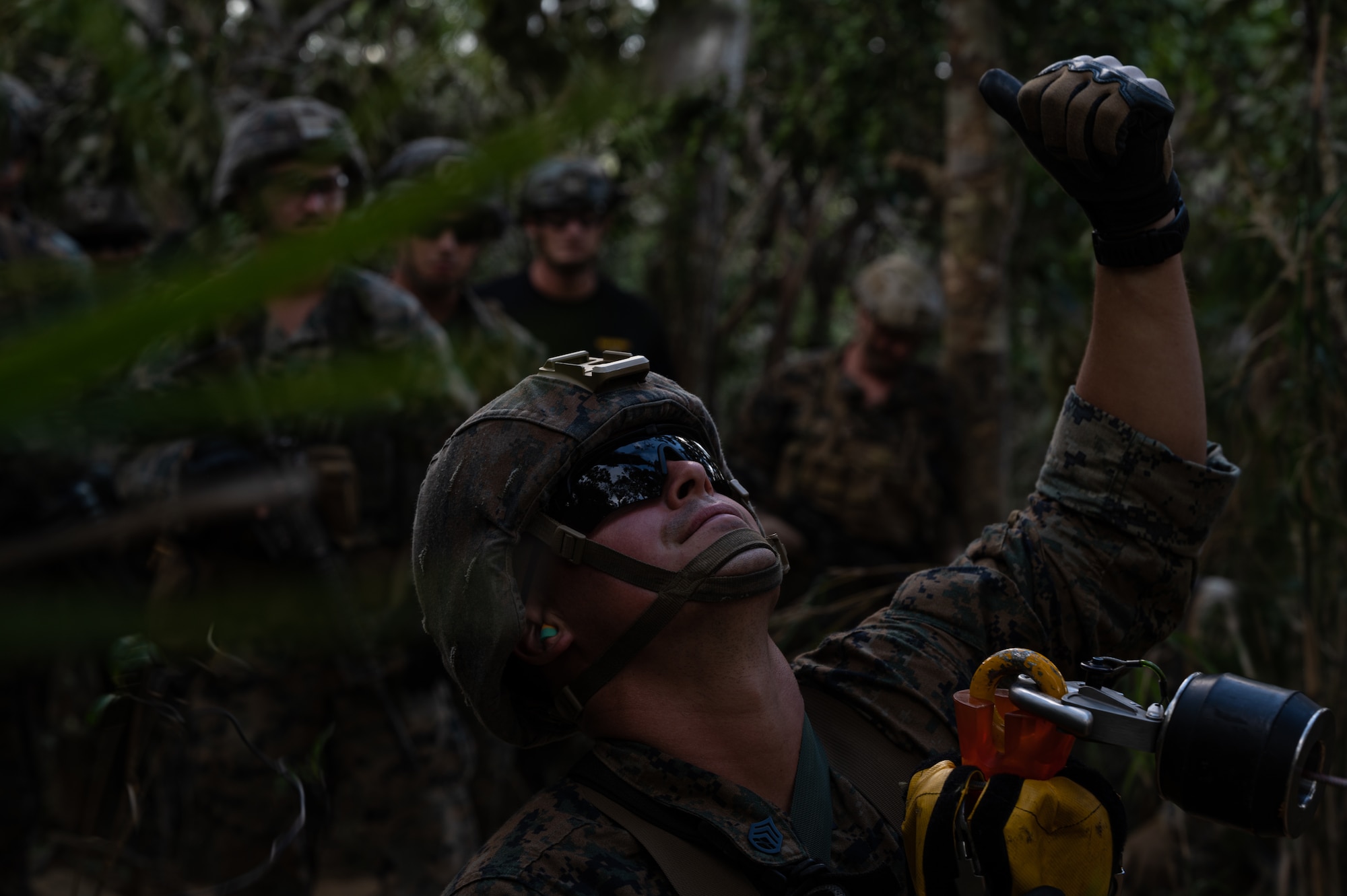 A U.S. Marine from the 3rd Reconnaissance Battalion signals to a 33rd Rescue Squadron HH-60 Pavehawk helicopter at the Jungle Warfare Training Center on Camp Gonsalves, Japan, Sept. 23, 2021. The mission of Recon Marines is to conduct amphibious reconnaissance, deep ground reconnaissance, surveillance and battle-space shaping. (U.S. Air Force photo by Airman 1st Class Stephen Pulter)
