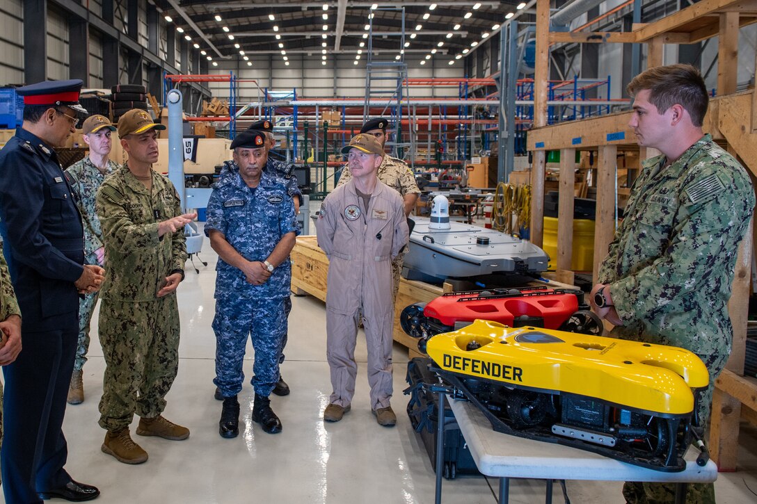 Vice Adm. Brad Cooper, commander of U.S. Naval Forces Central Command (NAVCENT), U.S. 5th Fleet and Combined Maritime Forces, center left, along with Major Gen. Ala Abdulla Seyadi, commander of the Bahrain Coast Guard, left; and Rear Adm. Mohammed Yousif Al Asam, commander of the Royal Bahrain Naval Force, center right, listen to a presentation on remotely operated unmanned underwater vehicles. During the visit, Bahraini leaders committed to partnering with NAVCENT to accelerate integration of new unmanned systems into regional maritime operations.