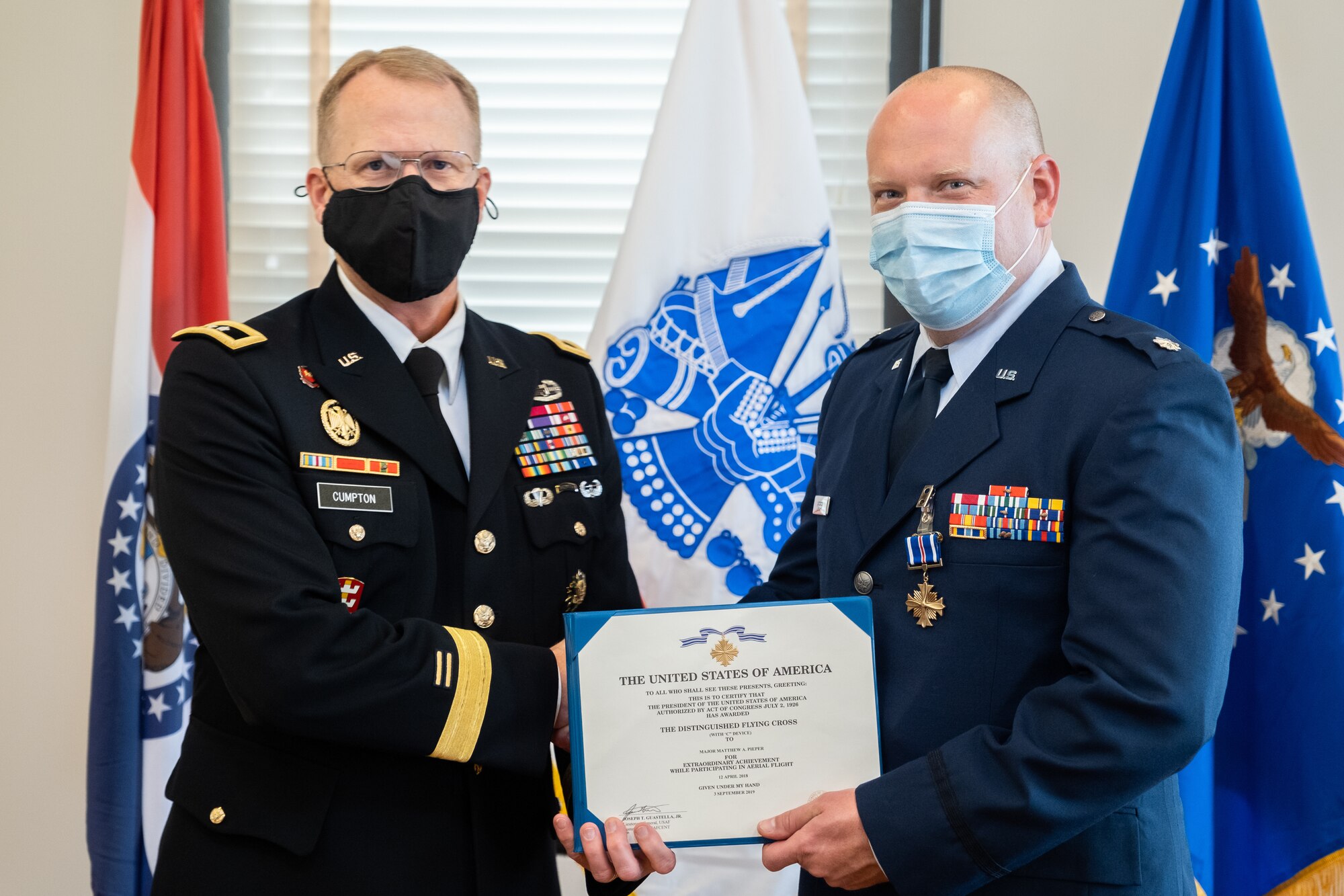 Adjutant General of the Missouri National Guard Maj. Gen. Levon Cumpton presents Lt. Col. Matthew Pieper, a Center for Sustainment of Trauma and Readiness Skills instructor, with the Distinguished Flying Cross during a ceremony at Jefferson Barracks Air National Guard Base, Missouri, September 12, 2021. Pieper was decorated for his lifesaving actions during a 2018 aeromedical evacuation flight while deployed to Afghanistan. (U.S. Air National Guard photo by Master Sgt. Stephen Froeber)