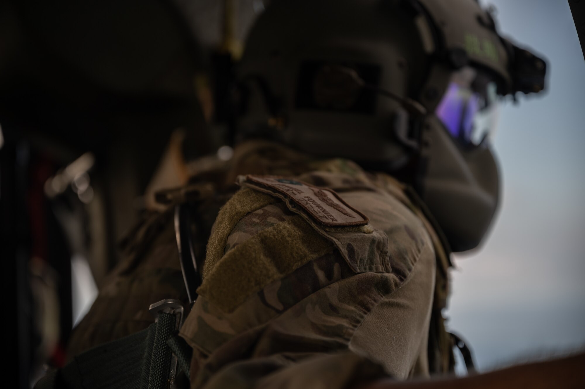 U.S. Staff Sgt. Daniel Fournier, 33rd Rescue Squadron special missions aviator, looks out of an HH-60 Pavehawk helicopter while flying over Okinawa, Japan, Sept. 23, 2021. Part of an SMA’s job consists of relaying information about objects in the pilot’s blind spots. (U.S. Air Force photo by Airman 1st Class Stephen Pulter)