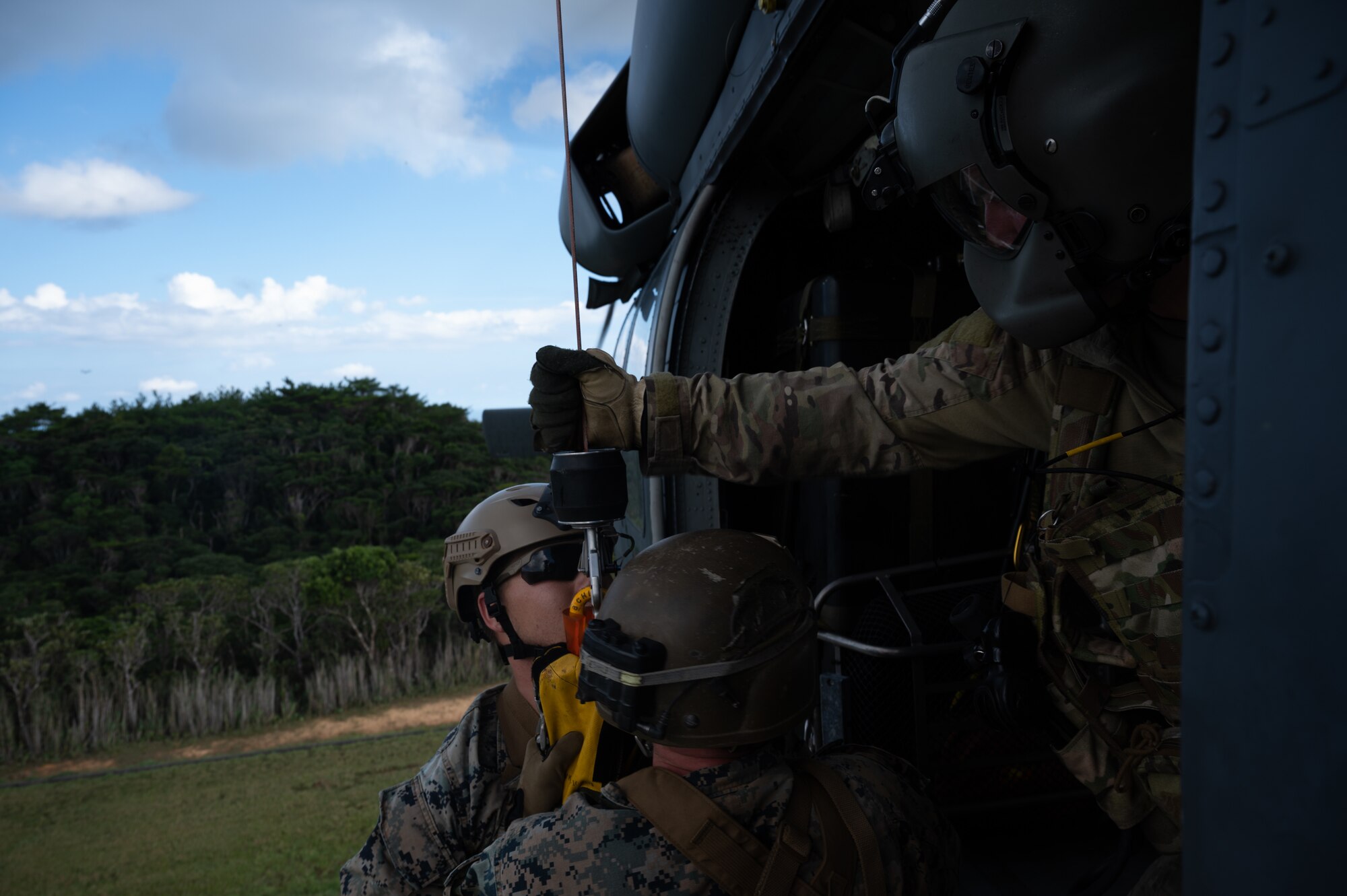Staff Sgt. Connor Farrell, 33rd Rescue Squadron special missions aviator, helps two U.S. Marines from the 3rd Reconnaissance Battalion enter an HH-60 Pavehawk helicopter at Camp Gonsalves, Japan, Sept. 23, 2021. Joint training ensures there’s a shared understanding of strategies, decision-making, method of operations and capabilities. (U.S. Air Force photo by Airman 1st Class Stephen Pulter)