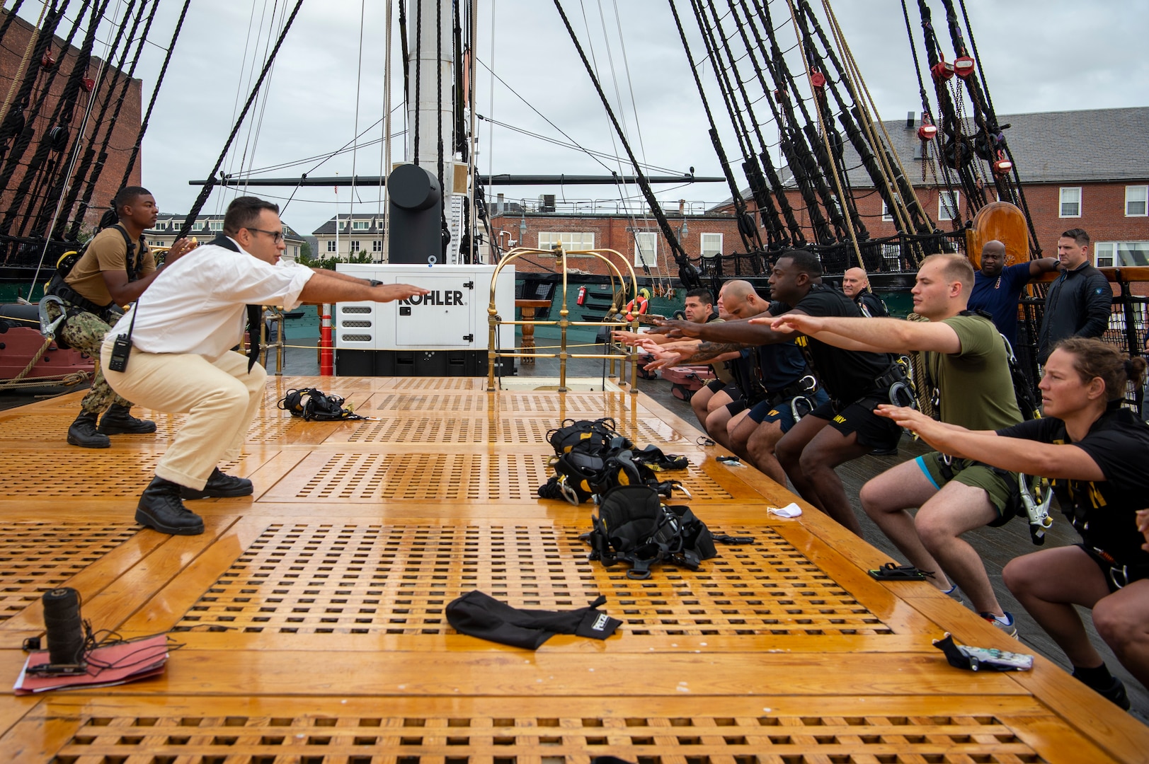 Service members of the United States Military Entrance Processing Command prepare to climb the shrouds aboard USS Constitution.