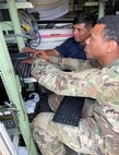 Dan Guzman, a U.S. Army Aviation and Missile Command Logistics Assistance Representative assigned to the 405th Army Field Support Brigade, assists a Soldier from Headquarters and Headquarters Troop, 2nd Cavalry Regiment with uploading system software updates on the Air and Missile Defense Workstation. Highly trained, LARs are Army civilians serving in motor pools, hangars, maintenance shops and offices around the world. They are part of the U.S. Army Sustainment Command’s global network of Army Field Support Brigades and are linked to every echelon of the Army in the field. (U.S. Army Courtesy photo)