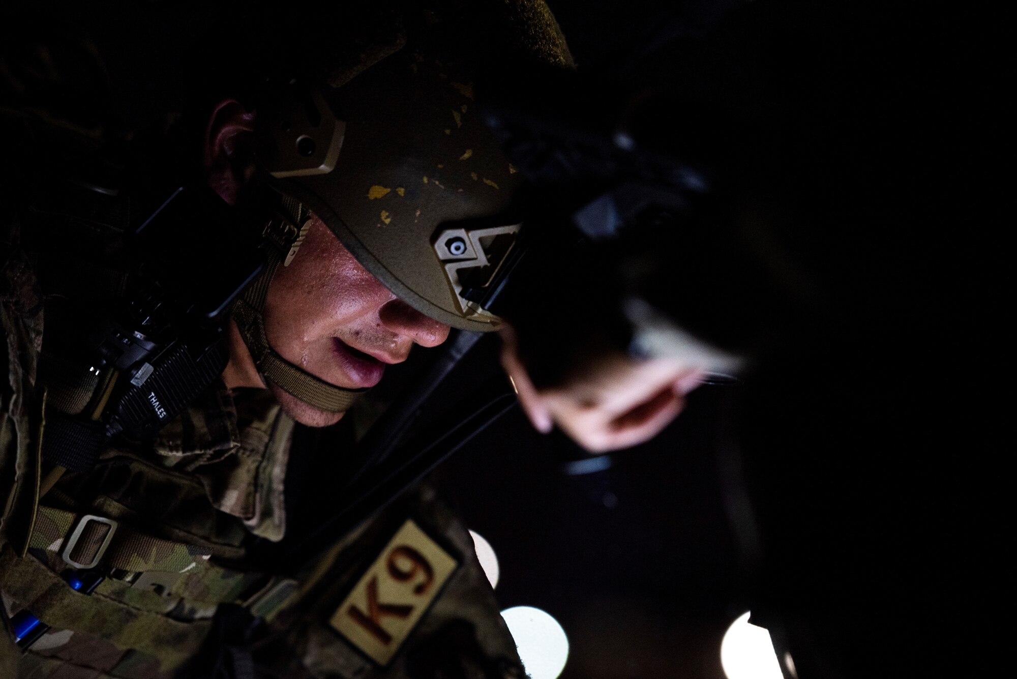 military working dog handler, performs tactical combat casualty care on a simulated dog during a joint K-9 helicopter training