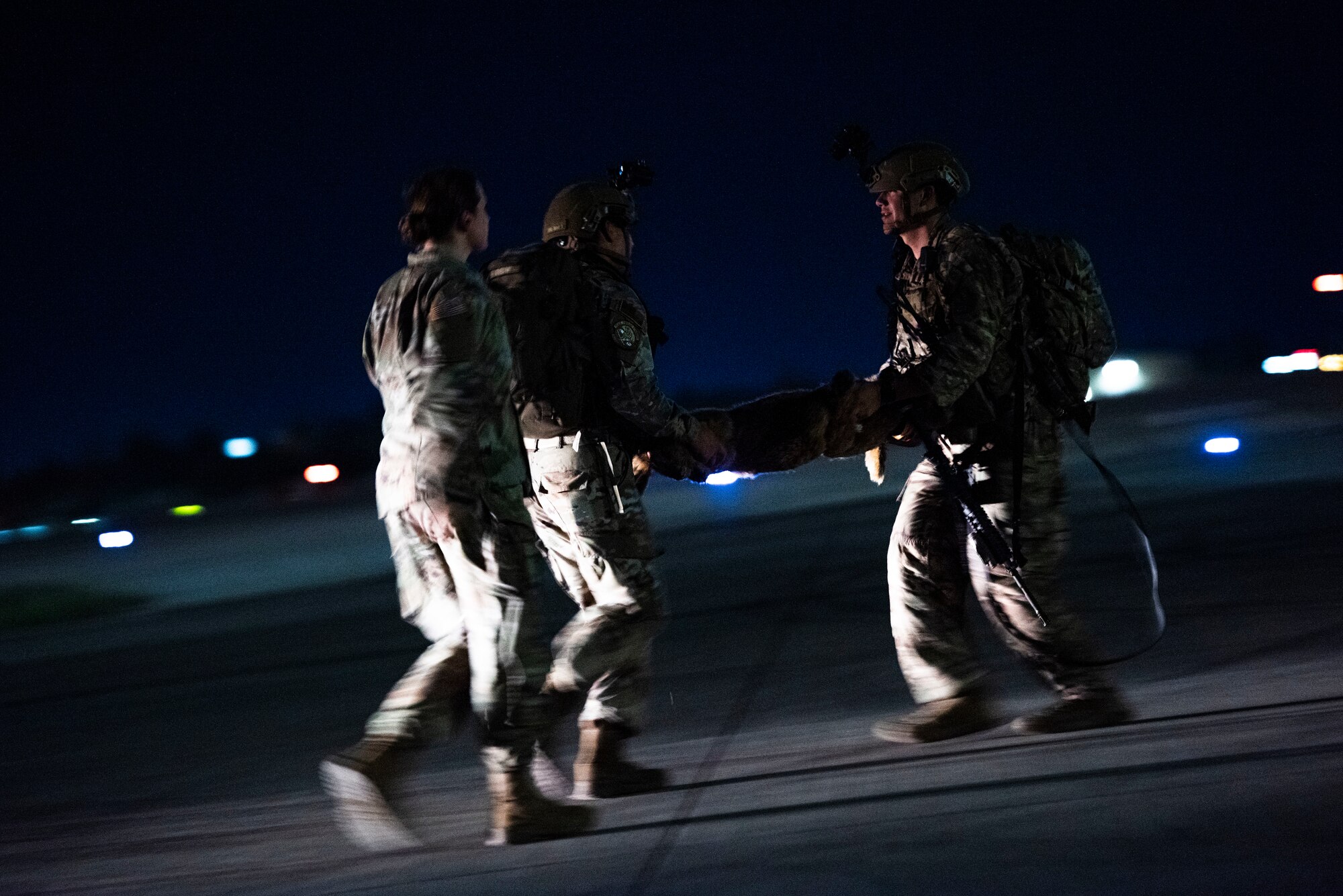 Military working dog handlers evacuate a simulated dog during a joint K-9 helicopter training mission