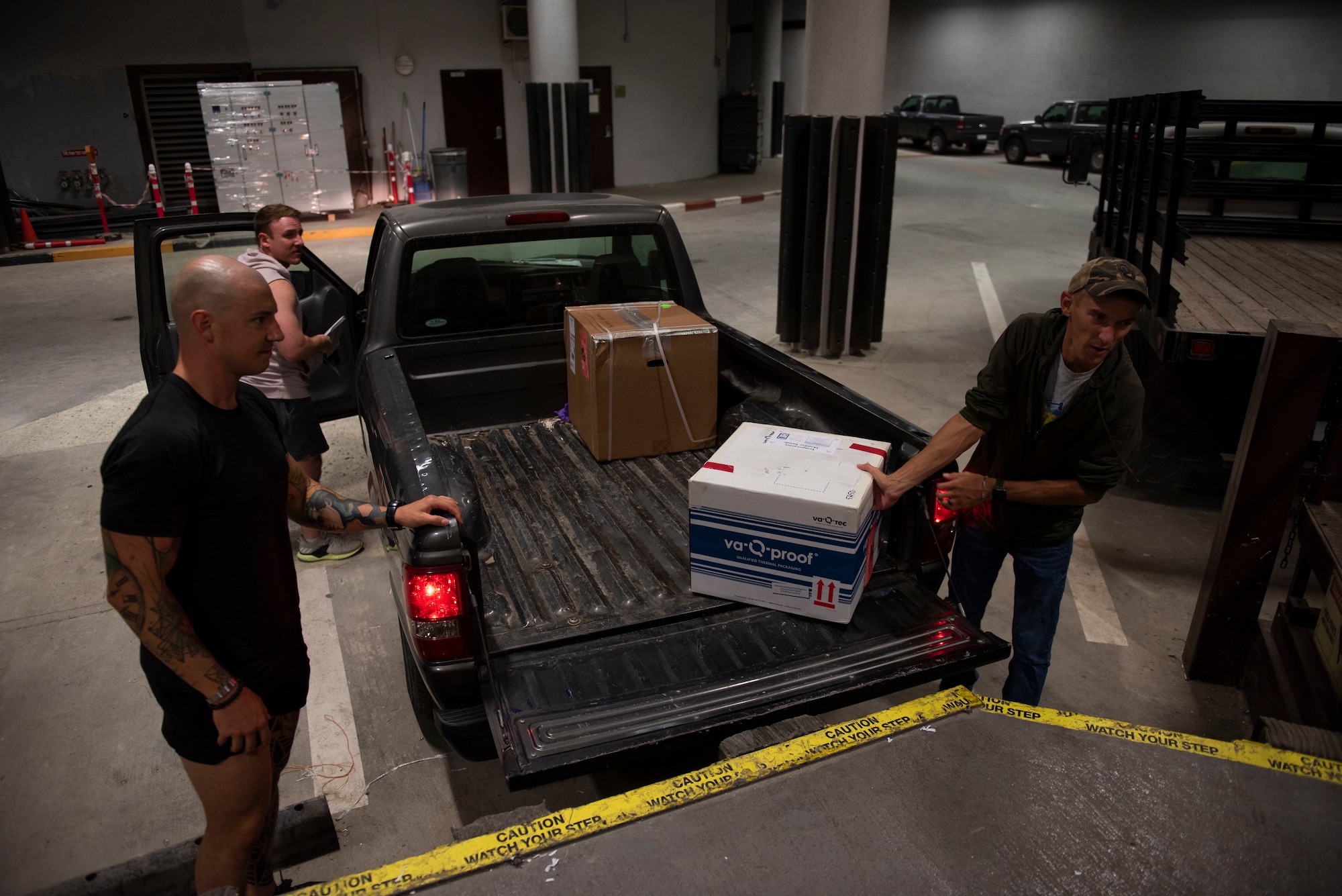 medical logistics technicians unload Food and Drug Administration approved COVID-19 vaccine doses from a truck