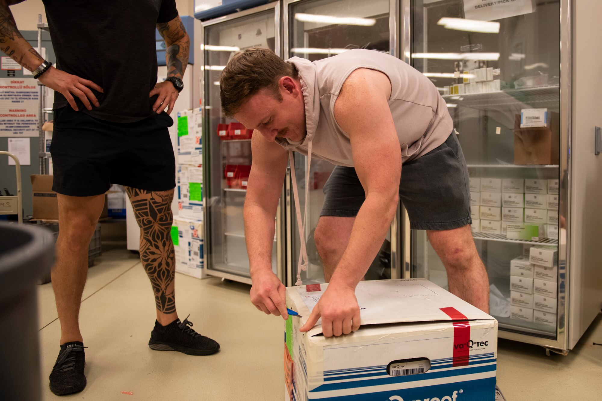 medical logistics technician removes Food and Drug Administration approved COVID-19 vaccine doses from a box