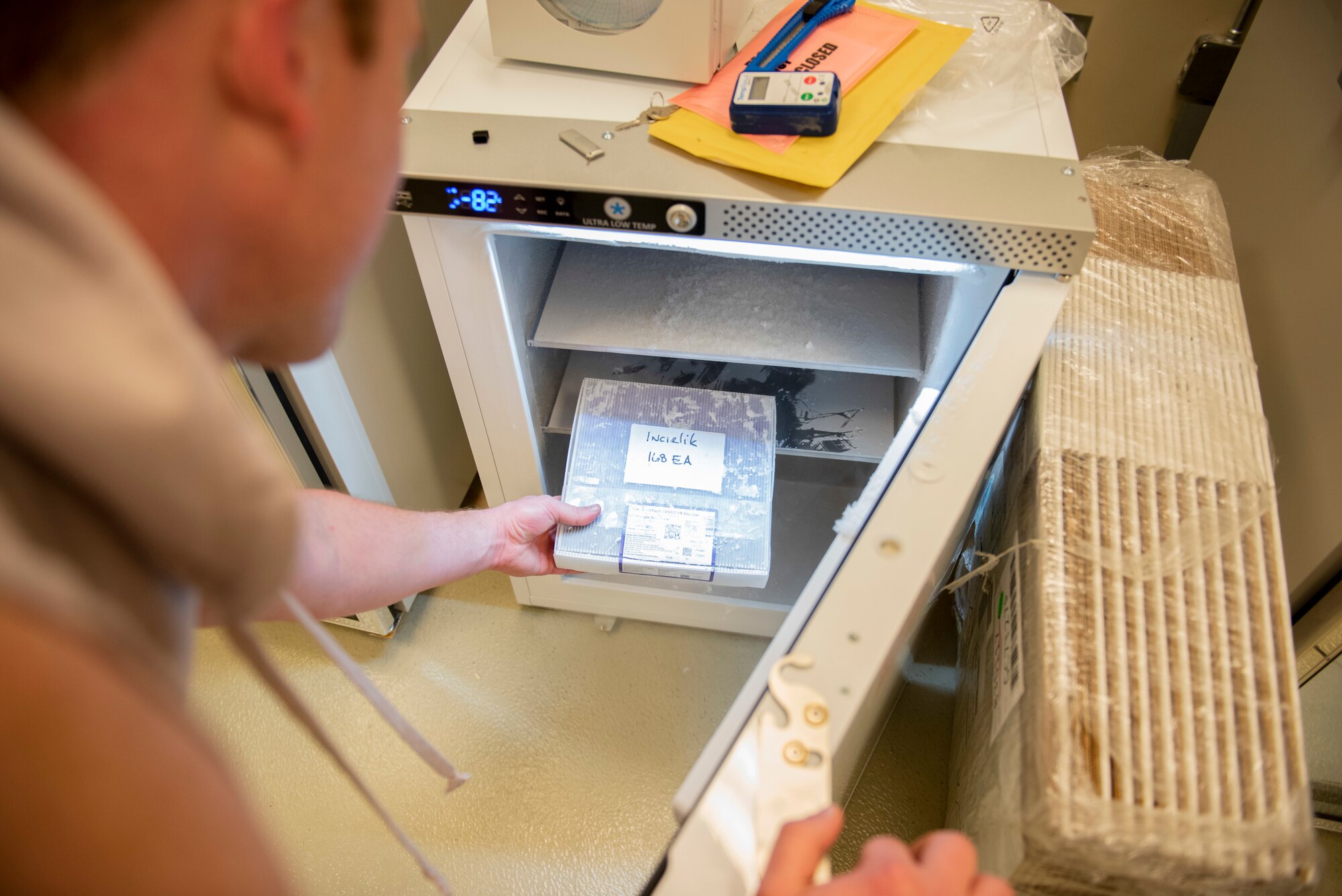 medical logistics technician stores Food and Drug Administration approved COVID-19 vaccine doses into a medical freezer