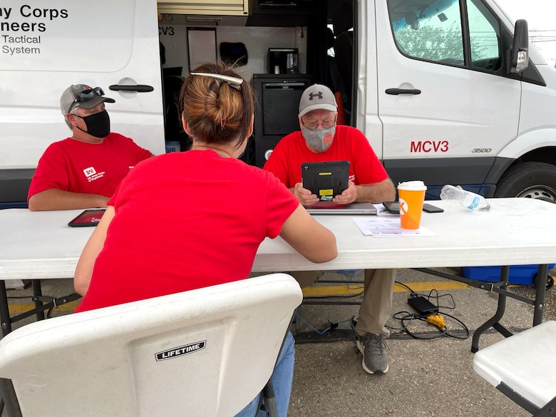 Employees with the U.S. Army Corps of Engineers assist local residents in Louisiana sign up for the Blue Roof Program in the wake of Hurricane Ida.