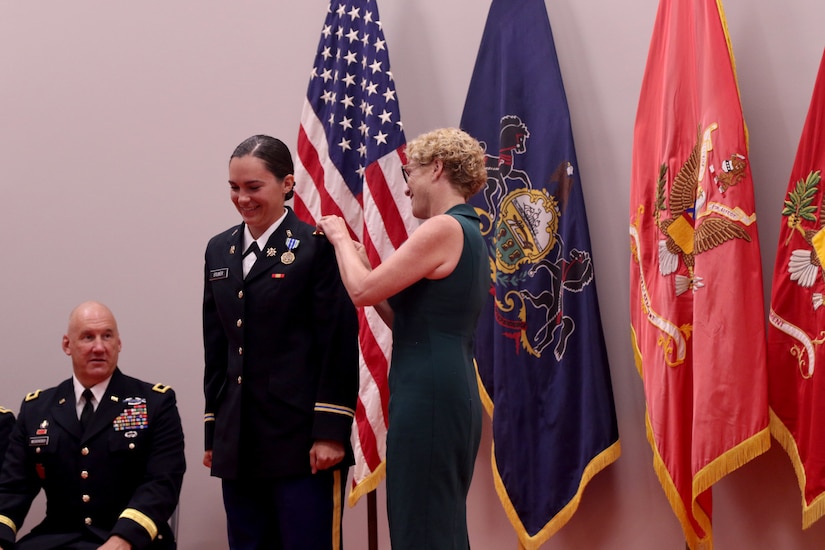 Rep. Christina Houlahan, a former Air Force officer and currently a Representative for Pennsylvania’s 6th District, pins 2nd Lt. Aubrey Stuber’s shoulder boards onto her uniform Aug. 8, 2021, at Fort Indiantown Gap. Stuber’s first assignment will be at the 28th Expeditionary Combat Aviation Brigade (ECAB) while serving as a Military Intelligence officer. (U.S. Army National Guard photo by 1st Lt. Amanda Westlund)
