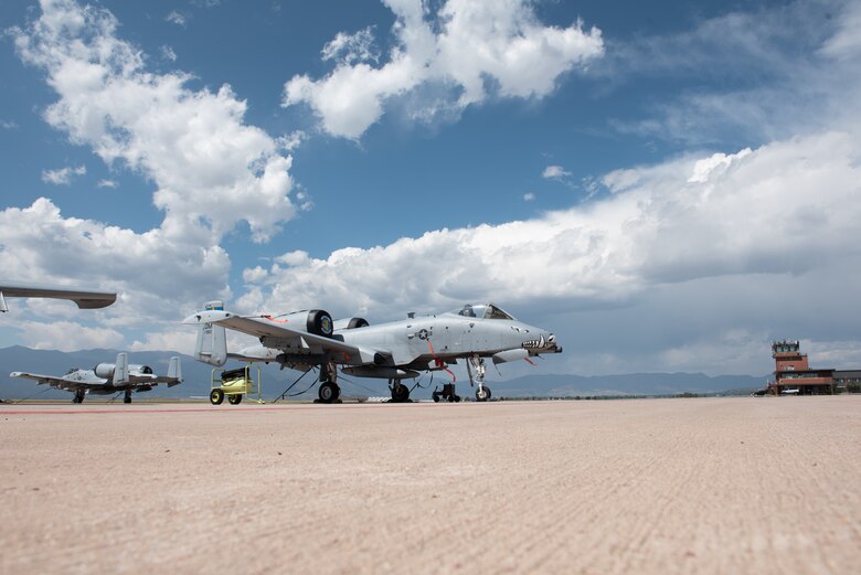 a-10 warthog sits on the flightline with pikes peak in the background