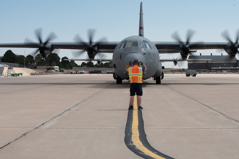fuels team member leads in a C-130 hercules on the flightline