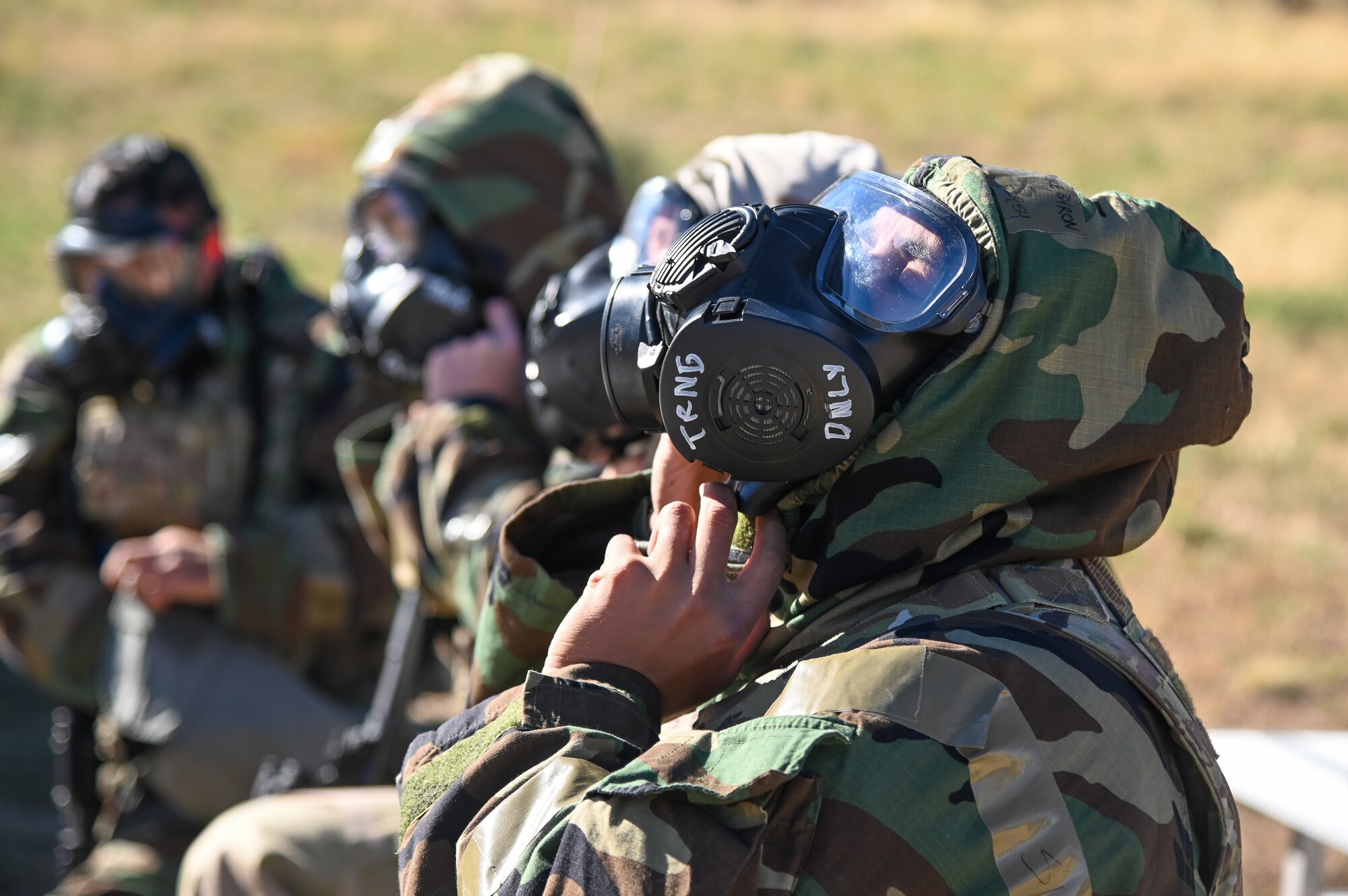 Master Sgt. Bryon Price, 75th Security Forces Squadron, seals his hood around his gas mask before a "Shoot, Move, Communicate" drill Sept. 22, 2021, at Hill Air Force Base, Utah. Squadrons from the 75th Air Base Wing participated in a phase II readiness exercise where they were assessed on performing tasks in an austere environment. (U.S. Air Force photo by Cynthia Griggs)