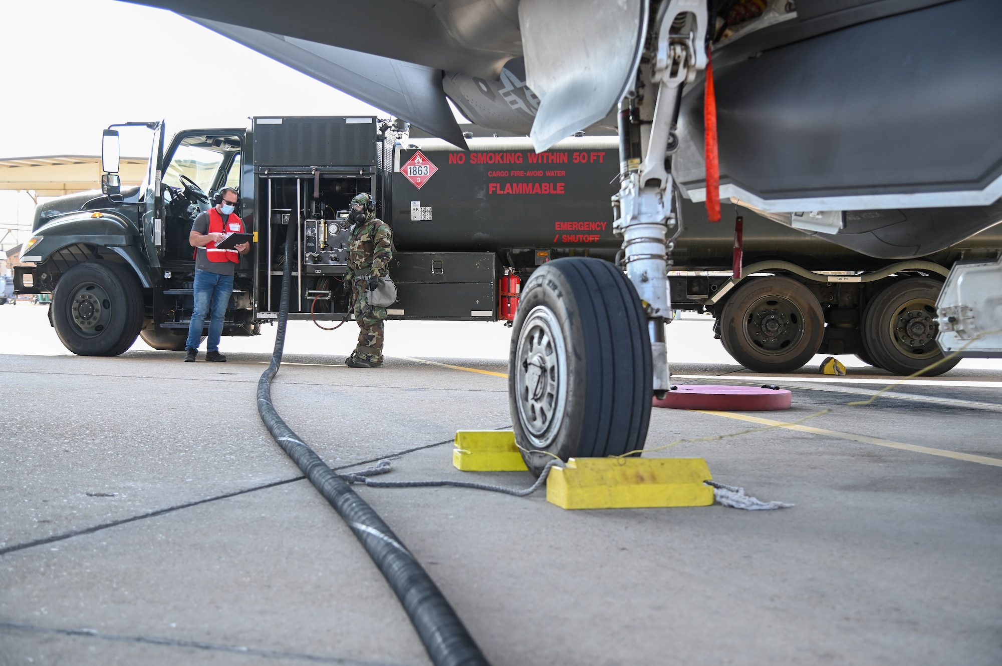 Staff Sgt. Joseph Gourley, 75th Logistics Readiness Squadron, fuels an F-35A Lightning II while being inspected by Wesley Jones, 75th LRS Wing Inspection Team, Sept. 22, 2021, at Hill Air Force Base, Utah. Squadrons from the 75th Air Base Wing participated in a phase II readiness exercise where they were assessed on performing tasks in an austere environment. (U.S. Air Force photo by Cynthia Griggs)