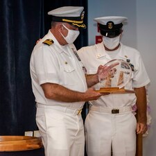 Capt. Keith Dowling, left, receives a plaque to remember his tour as commanding officer of the Center for Explosive Ordnance Disposal and Diving (CEODD) during a change of command and retirement ceremony, Sept. 22.  Dowling retired after nearly 38 years of service in the U.S. Navy.