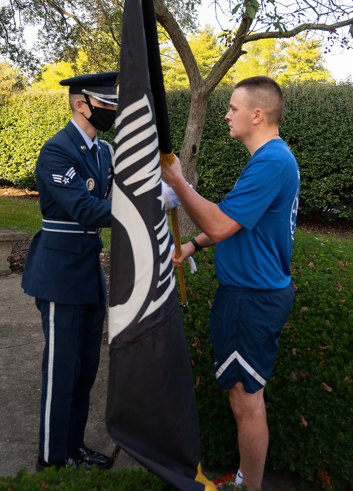 Chief Master Sgt. Chris Sutor, National Air and Space Intelligence Center,  hands the POW/MIA Flag to an Honor Guard Airman during the POW/MIA Recognition Day wreath-laying ceremony Sept. 17, 2021, at Wright-Patterson Air Force Base, Ohio. The flag was carried by runners on a 6.2-mile course through the base on its way to the ceremony.  (U.S. Air Force photo by R.J. Oriez)