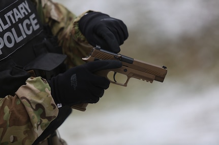 Soldier points out parts of new M17 pistol.