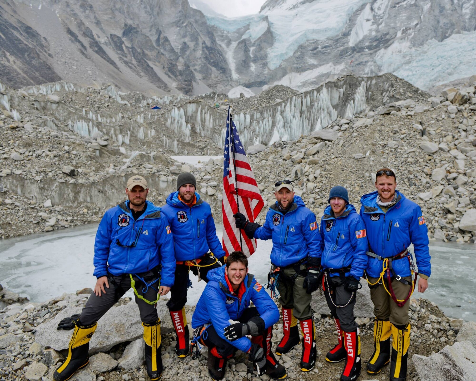 Seven Summit Challenge team stand with the American flag at a base camp on Mount Everest