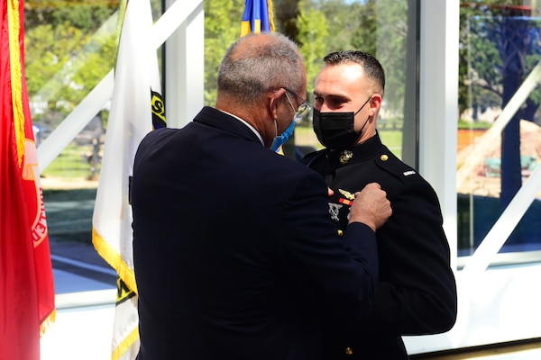Marine 1st Lt. Michael LoGrande is pinned with his weapons systems officer (WSO) Wings of Gold during a ceremony at the National Naval Aviation Museum at Naval Air Station Pensacola, Sept. 24, 2021.